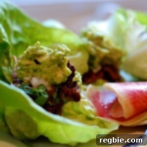Carnitas cooked sous vide wrapped in lettuce and topped with guacamole.