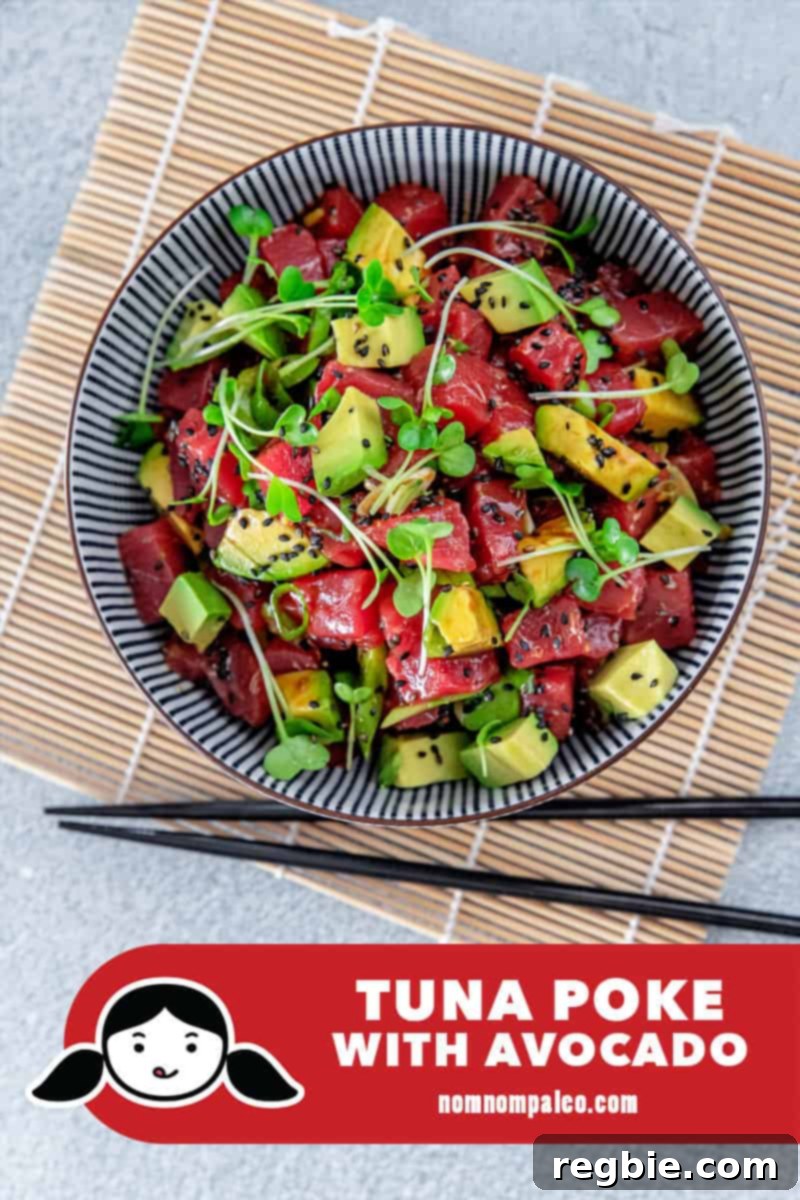 Clean Eating Tuna Avocado Poke 2 Overhead shot of a vibrant, healthy, paleo-friendly Tuna Poke with Avocado bowl, featuring diced tuna, creamy avocado, and green onions garnished with sesame seeds.