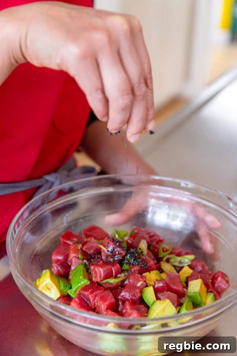 Clean Eating Tuna Avocado Poke 9 Sprinkling toasted sesame seeds and microgreens over the freshly mixed Whole30 tuna poke with avocado for a perfect finish.