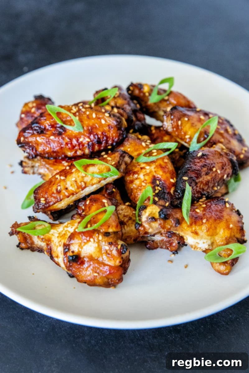 A pristine white plate generously piled with succulent Whole30, gluten-free, and paleo Chinese Chicken Wings, presented as an irresistible game day appetizer.
