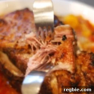 A bowl of slow cooker pork pot roast with shredded meat and vegetables, ready to serve.