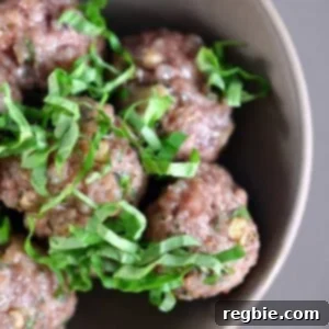 Delicious Lemon Ginger Meatballs on a baking sheet, garnished with fresh herbs.