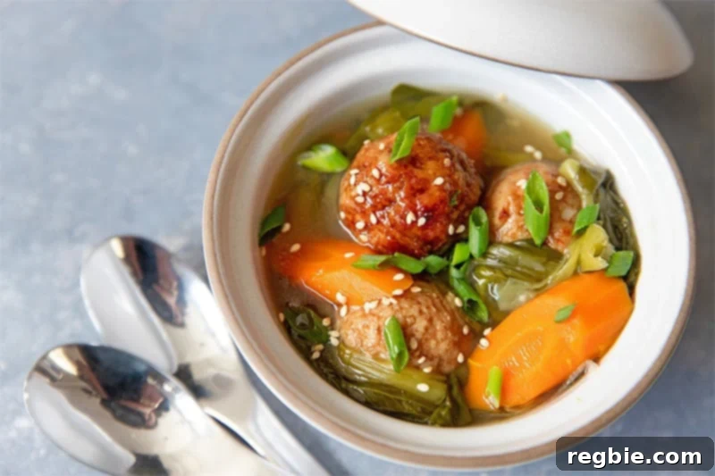A comforting bowl filled with Instant Pot Vegetable Soup, generously topped with savory meatballs.