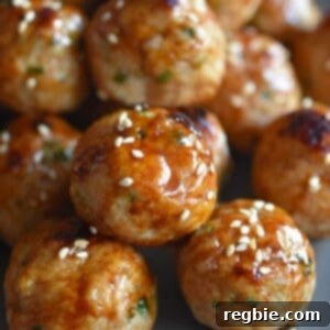 A platter of Whole30 and Paleo-friendly tsukune, Japanese ground chicken meatballs, garnished with green onions and sesame seeds.