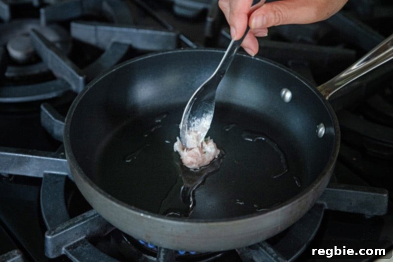 Frying a small patty of Japanese chicken meatball mixture to test the seasoning before cooking the batch.
