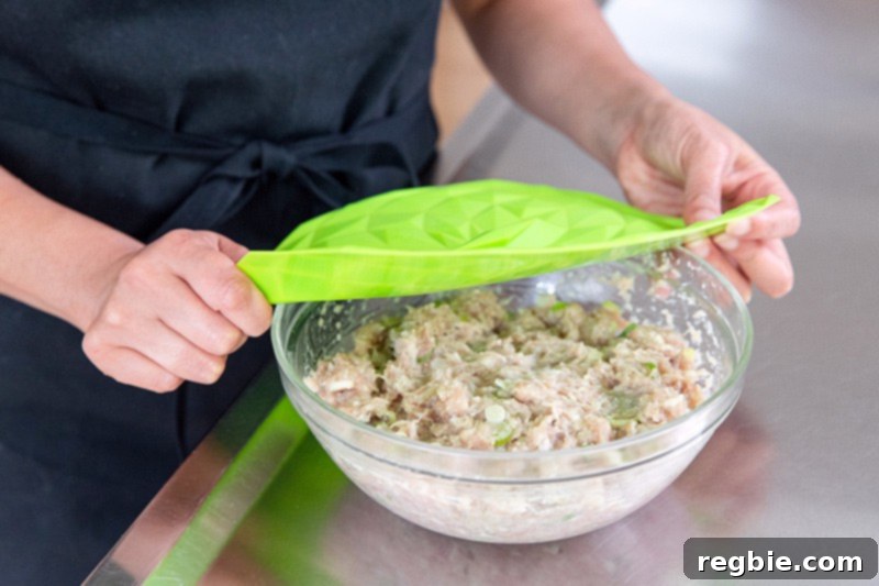 Covering the raw tsukune mixture with a silicone lid before placing it in the fridge to chill.