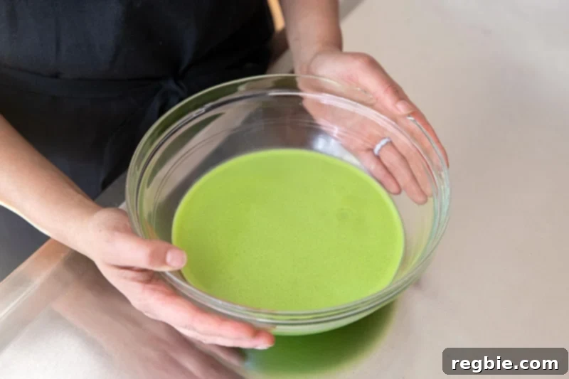 Creamy Paleo Dairy Free Matcha Pudding 10 A medium-sized bowl filled with a smooth, vibrant green matcha pudding mixture, ready to be placed in the refrigerator for chilling.