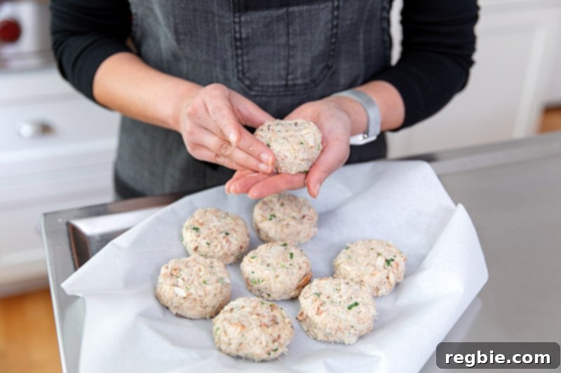 Forming gluten-free and keto crab cakes on a parchment paper lined plate.