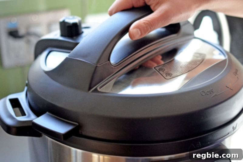 Locking the lid on the Instant Pot, ensuring it's sealed and ready for pressure cooking the Kalua Pig.