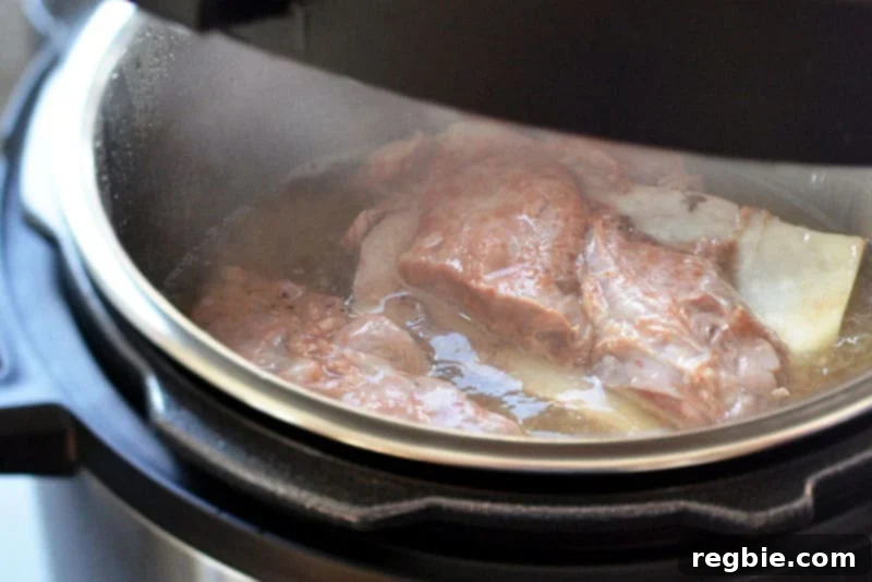 The Instant Pot displaying '00' and 'Keep Warm' mode, indicating the Kalua Pig is fully cooked and depressurized.