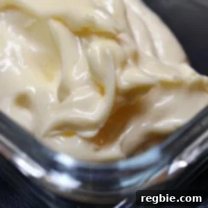 A closeup of thick and creamy paleo mayonnaise in a glass container.