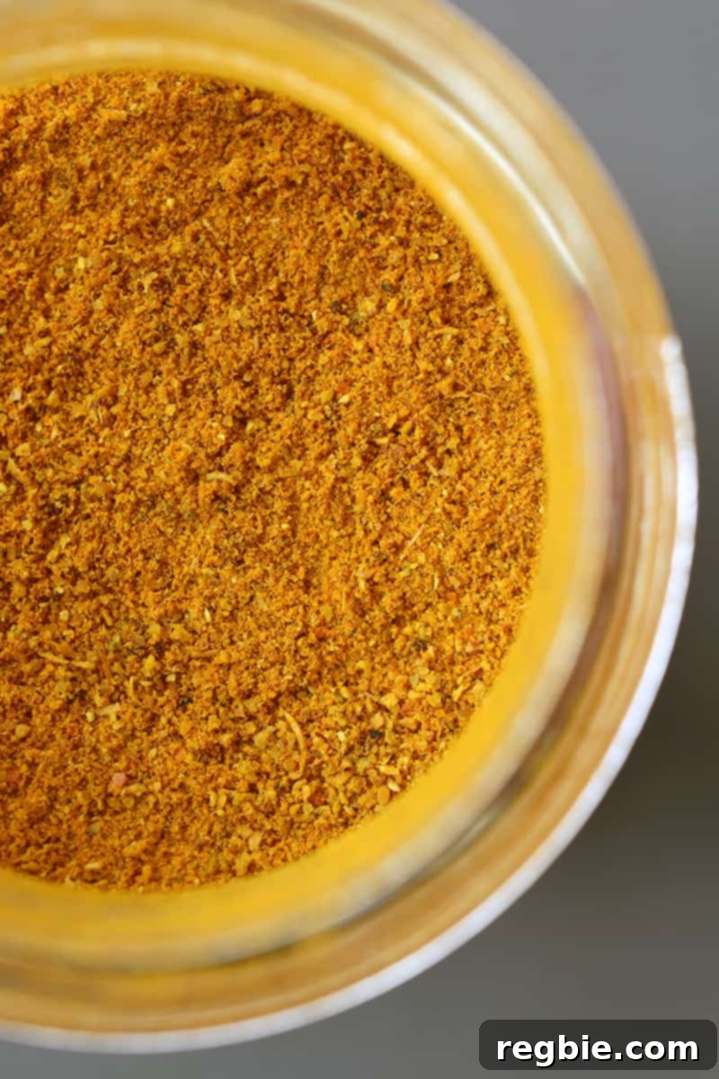 An overhead shot of an open jar of fragrant Indian Madras curry powder, ready to season the cauliflower.