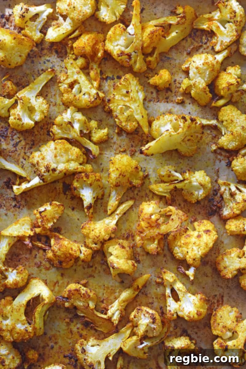 An overhead shot of vibrant Roasted Curried Cauliflower, fresh from the oven, glistening with spices.