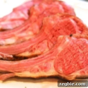 Sous Vide Lamb Rack Perfection 2 A rack of lamb cut into it's chops laying on a white plate.