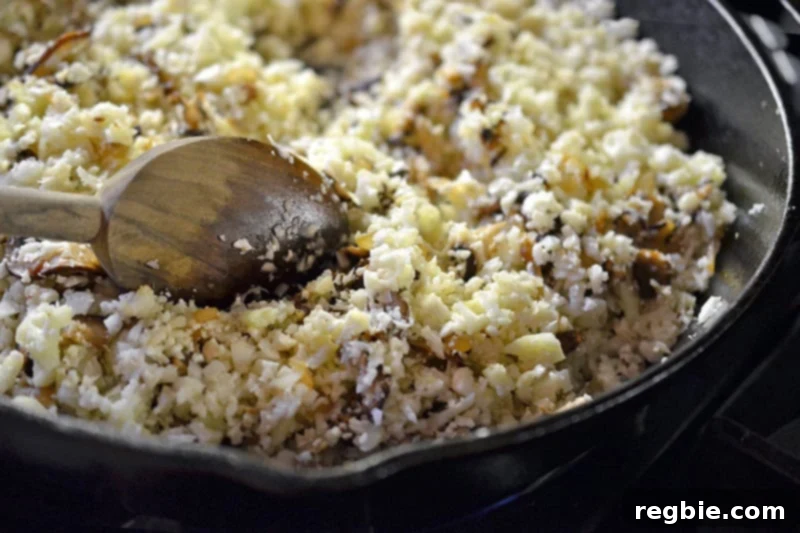Better-Than-Takeout Asian Cauliflower Fried Rice 13 Adding the prepared cauliflower rice to the hot skillet with other ingredients