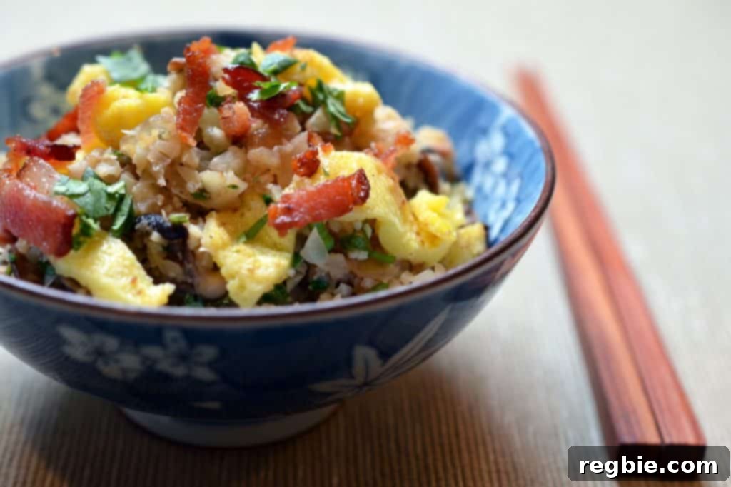 Better-Than-Takeout Asian Cauliflower Fried Rice 15 A side shot of Asian Cauliflower Fried Rice in a blue bowl with chopsticks, ready to serve