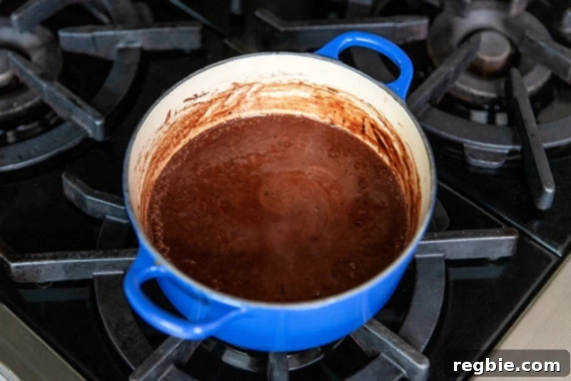 Heavenly Paleo Chocolate Pudding 6 Closeup of the dairy-free chocolate pudding in a blue sauce pan after it has simmered and taken off the heat.