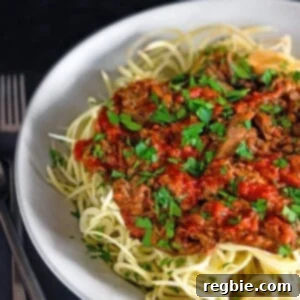 Easy Instant Pot Meat Sauce Whole30 Keto 13 A large white bowl filled with spiralized sweet potato noodles topped with Whole30 Instant Pot Meat Sauce, an easy and healthy dinner.