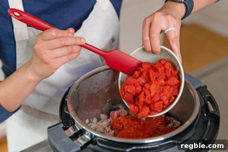 Easy Instant Pot Meat Sauce Whole30 Keto 7 Adding drained diced tomatoes to the Instant Pot to make an easy meat sauce.