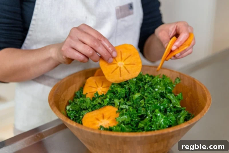Adding thin slices of fuyu persimmons to a healthy kale salad dressed with a lemon vinaigrette