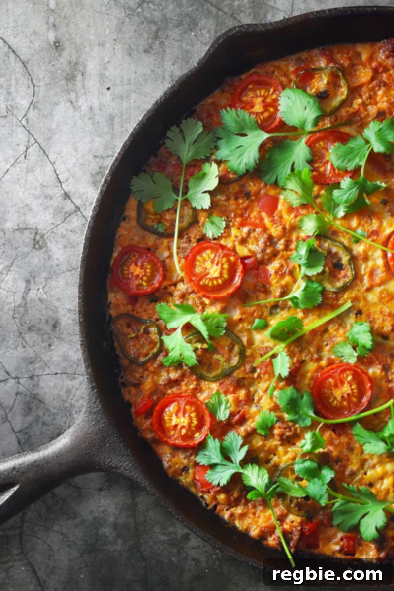An overhead shot of a cast iron skillet filled with paleo, keto, and Whole30 Tex-Mex Beef and Rice Casserole, a grain-free, one-pan dinner!