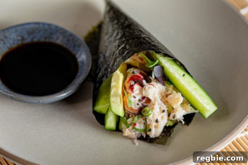 A delightful close-up shot of a perfectly formed homemade California hand roll, brimming with fresh crab, creamy avocado, and crisp cucumbers, ready to be enjoyed.