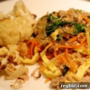 A plate with roasted cauliflower and paleo and whole30 stir fried kelp noodles with pork, eggs, and broccoli slaw.
