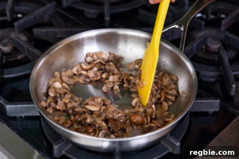 Inferno Eggs 7 An overhead shot of a stainless steel skillet filled with sautéed mushrooms where the liquid has evaporated.