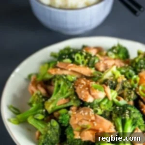 A large white platter topped with Whole30, paleo, and gluten-free chicken and broccoli stir fry in front of a blue bowl of cauliflower rice.