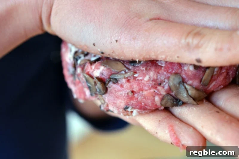 Someone forming patties of the paleo big-o bacon burgers, ensuring uniform thickness.