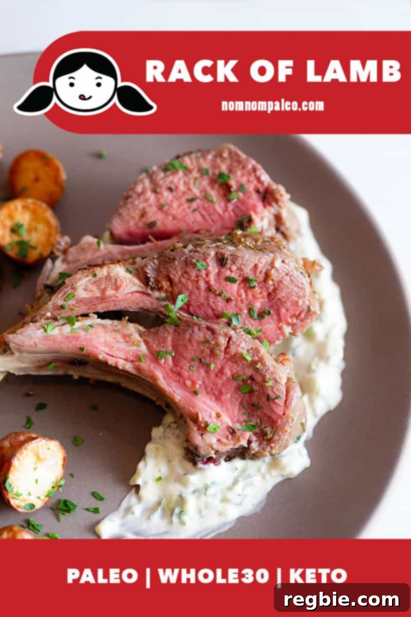 Three perfectly cooked, medium-rare lamb chops, cut from a rack of lamb, elegantly plated atop a creamy Whole30 tzatziki sauce, viewed from overhead.