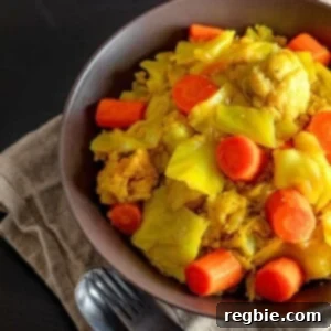 An overhead shot of a rustic brown bowl filled to the brim with ready-to-eat Atakilt Wat, Ethiopian cabbage stew, garnished with fresh herbs.