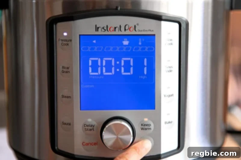 An Instant Pot display clearly showing '00:01' and the 'Pressure Cook' button illuminated, signifying the appliance is actively cooking on high pressure for one minute.