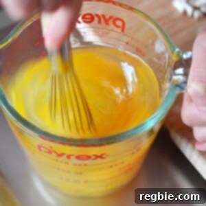 Someone whisking eggs in a Pyrex measure glass.