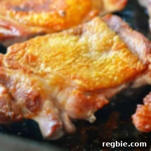 Flawlessly Tender and Crispy Sous Vide Chicken Thighs 3 Sous vide crispy chicken frying in a cast iron skillet.