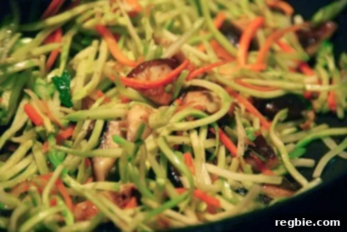 A vibrant and healthy stir-fried shiitake and broccoli slaw, featuring earthy mushrooms and crisp vegetables, cooked in a large cast iron skillet.