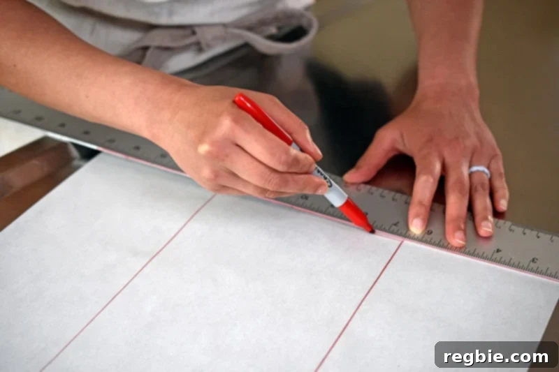 A person tracing a 14x6 inch rectangle onto a sheet of parchment paper with a red pen, preparing a guide for the dough.
