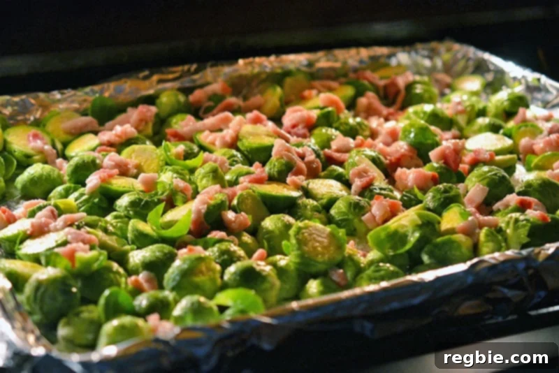 Roasted Brussels Sprouts and Bacon baking in the oven, showing the ingredients starting to crisp.