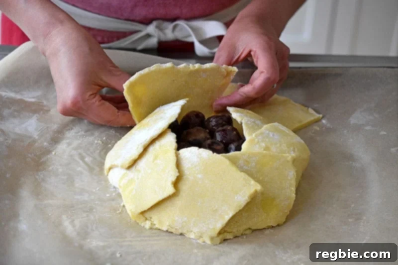 Someone folding the final dough flap on top of the paleo galette.