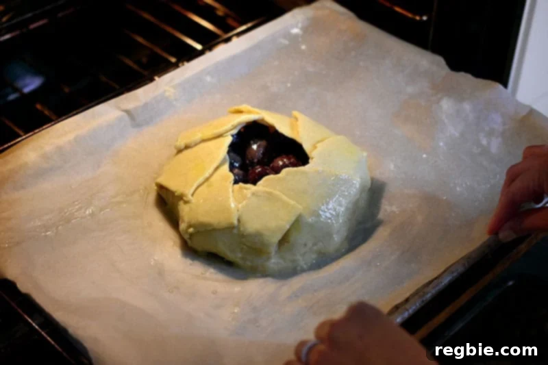 Placing a paleo cherry crostata into the oven.