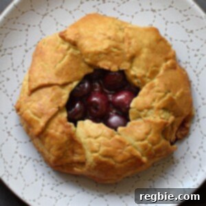 An overhead shot of paleo and gluten-free cherry galette on a white plate