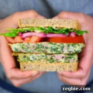 A closeup shot of someone holding a paleo St. Paul sandwich that has been sliced in half.