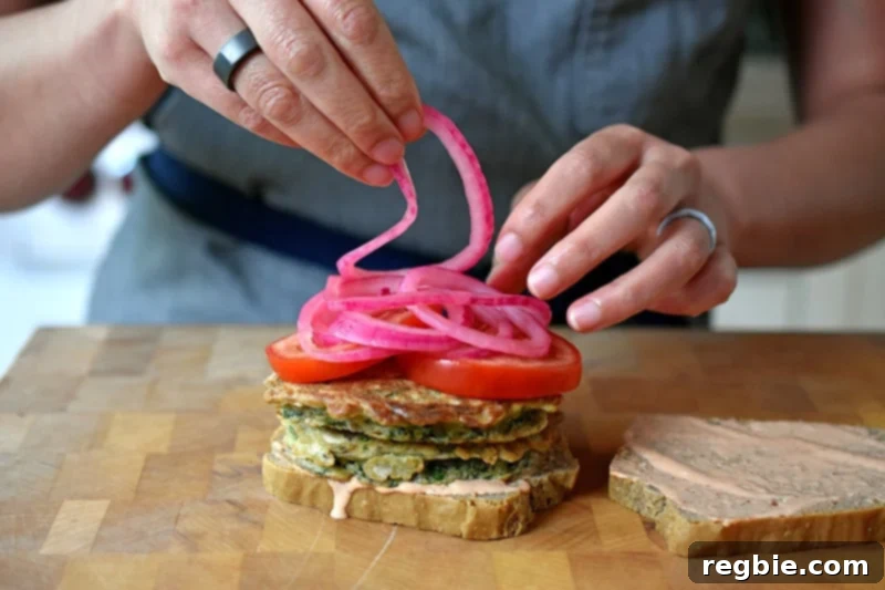 Adding quick pickled onions on a paleo and gluten-free St. Paul sandwich assembly.