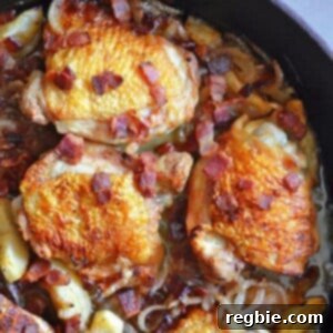 Delicious pan-roasted chicken with crispy bacon, caramelized apples, and fresh thyme in a cast iron skillet