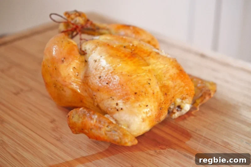 A perfectly cooked Weeknight Roast Chicken resting on a cutting board, allowing its juices to redistribute for maximum tenderness.
