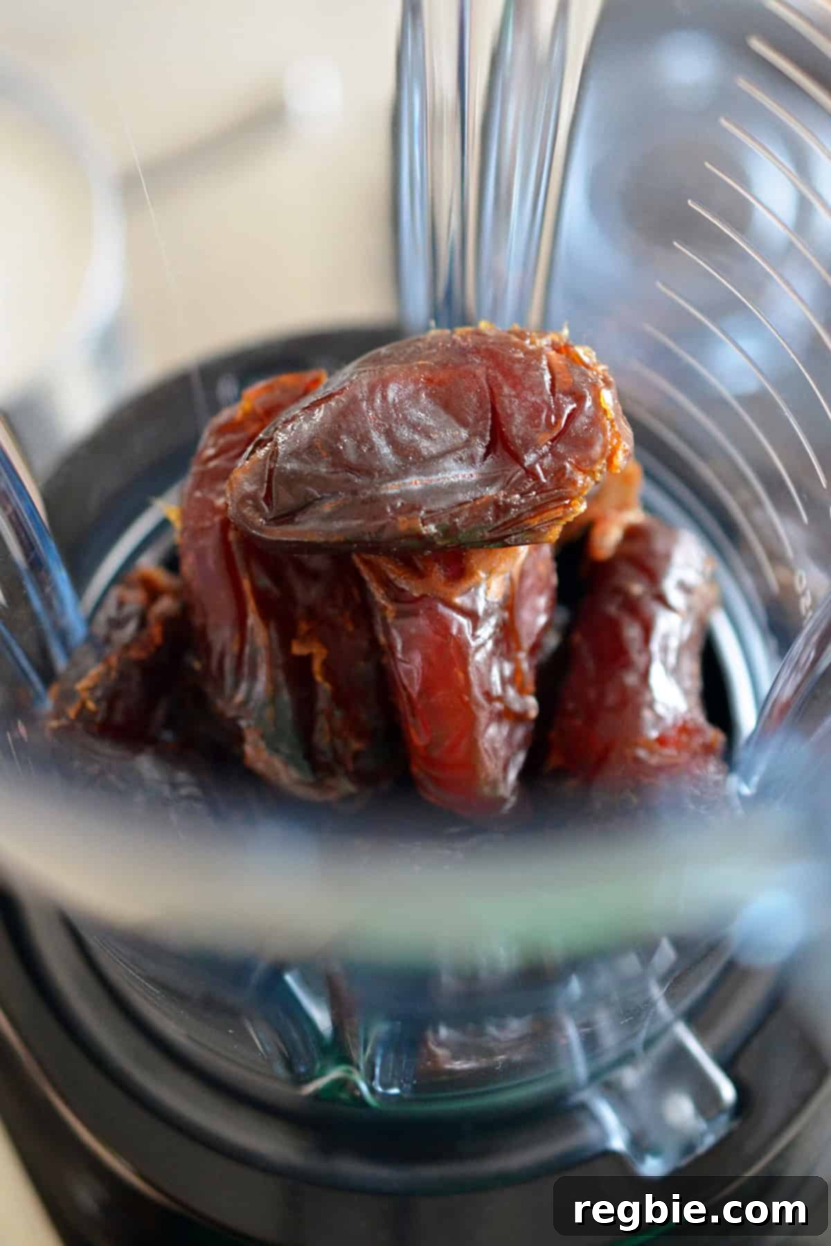A close-up shot of pitted Medjool dates placed in an open blender cup, ready for the next step of the recipe.