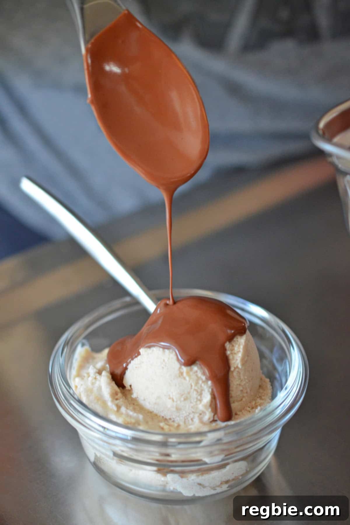 Luxurious chocolate ganache being drizzled over a creamy scoop of vanilla ice cream, creating a delightful contrast.