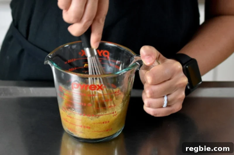 Quick Paleo Gluten-Free Pumpkin Mug Cake 5 Someone whisking the pumpkin mug cake batter in a liquid measuring cup.