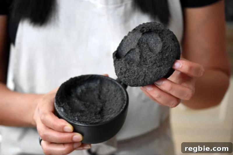 Paleo Black Sesame Mug Cake Indulgence 3 Someone revealing the moist, dark interior of a black sesame mug cake, showcasing its unique texture.