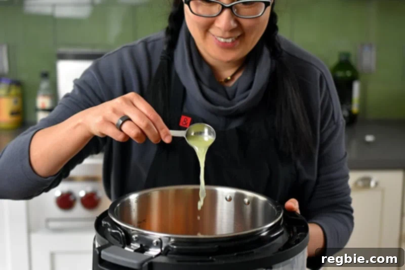 A brunette smiling lady is pouring fresh lime juice into an open Instant pot